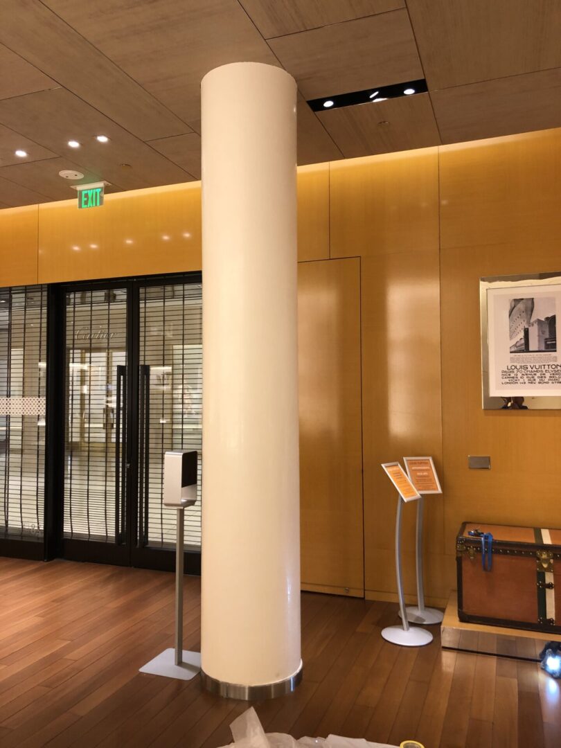 A room with pillars and a large glass door.