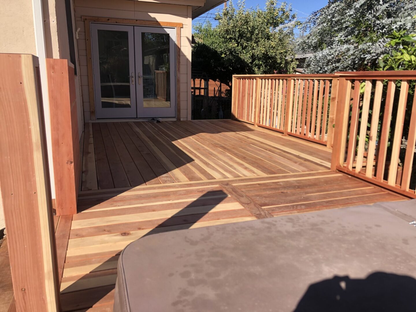 A wooden deck with a hot tub in the middle of it.