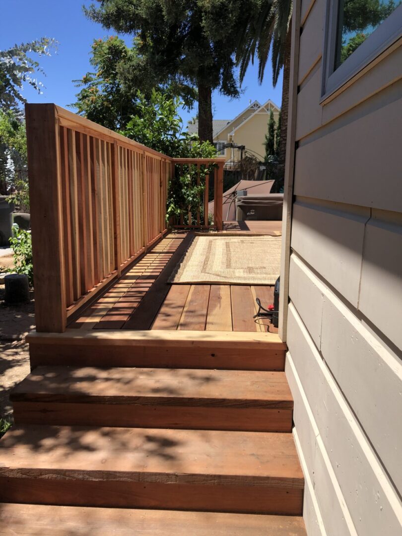 A wooden deck with steps leading to the back of it.