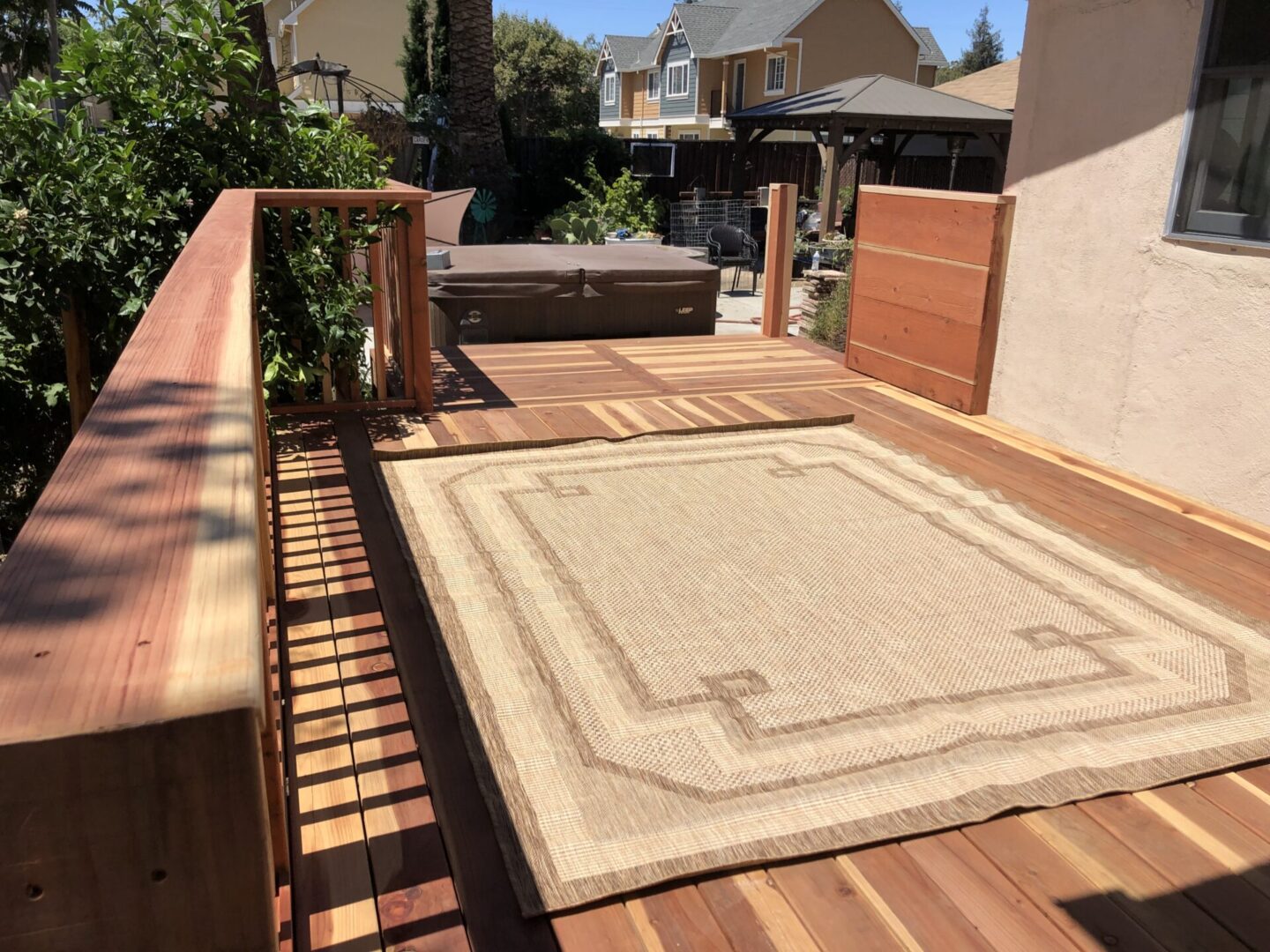 A deck with a rug and a hot tub