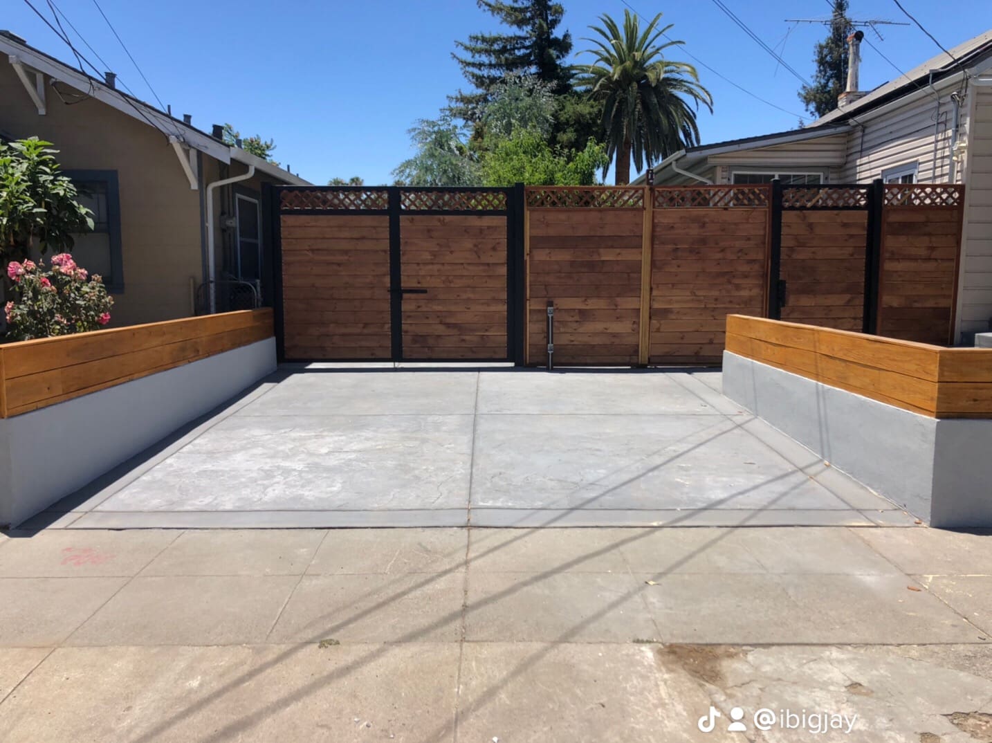 A concrete slab with wood fence and palm trees in the background.