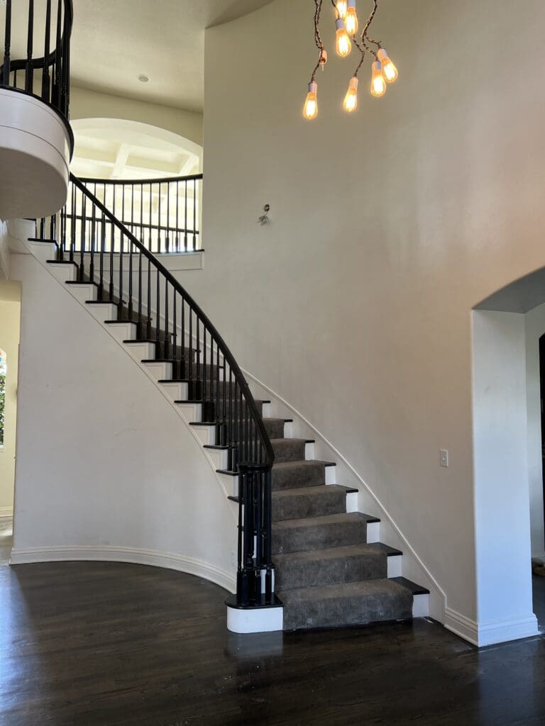 A staircase with black and white carpet on the bottom.